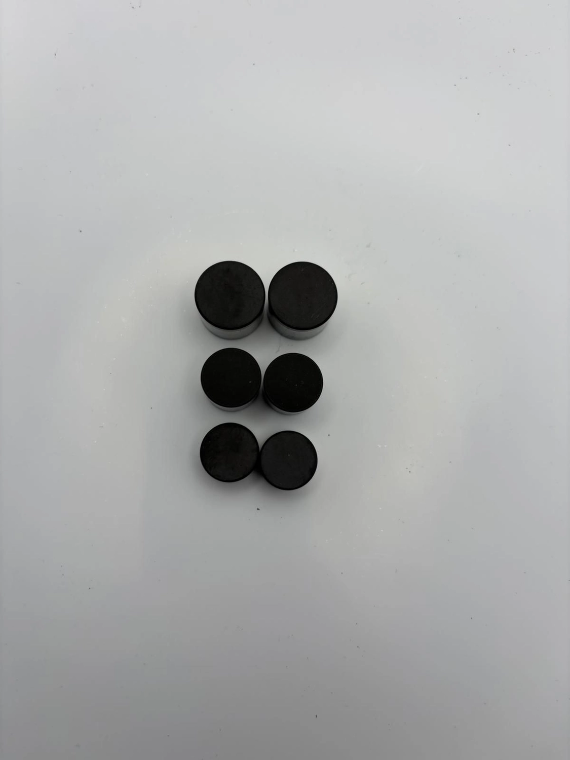 H-Tools - Hochleistungs-Gesteinsbohrkronen - Sechs schwarze, zylindrische Industrieschneidplatten sind in zwei vertikalen Dreierreihen auf einer weißen Fläche angeordnet.